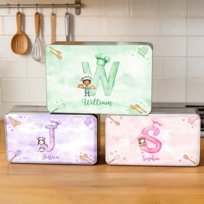 Personalisierte Keksdose mit Deckel und Anfangsbuchstaben eines Cartoon-Backmotivs (Junge/Mädchen), ideal als Geschenk zum Kindertag oder Geburtstag.